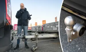 Man kontrollerar kopplingen till en släpvagn, kanske för att säkerställa att fordons totalvikt inte överskrids.