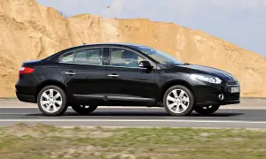 Czarny Renault Fluence jedzie po drodze, w tle piaszczyste wzgórza.