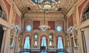 Wnętrze pałacu poznańskiego z bogatymi zdobieniami, żyrandolami i niebieskim sufitem.