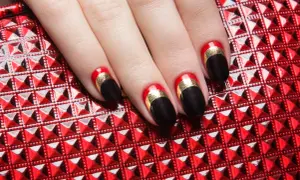 Czarne paznokcie z czerwonym i złotym akcentem – świetny pomysł na eleganckie paznokcie.