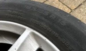 Oznaczenia opon: 185/55 R 15 82T. Widoczna felga aluminiowa.