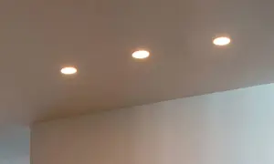 Trois spots encastrés éclairent un plafond. La lampe LED offre des avantages, mais il faut aussi considérer ses inconvénients.