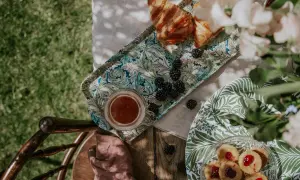 En härlig sommar fika med croissanter, björnbär och småkakor på ett vackert mönstrat fat.