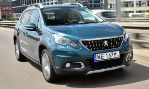 Turkusowy Peugeot 2008 na drodze. Kierowca w środku. Wiele pozytywnych peugeot 2008 opinie o tym modelu.