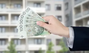 Dłoń trzyma banknoty 100 zł. Zastanawiasz się, ile wynosi dodatek mieszkaniowy?