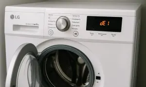 Pralka LG Direct Drive 6 kg z otwartymi drzwiczkami. Na wyświetlaczu widoczny błąd OE, wskazujący na problem z odprowadzaniem wody.