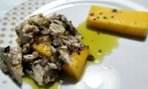 Piatto di luccio in umido con polenta gialla, condito con erbe aromatiche e olio. Un sapore autentico da provare!
