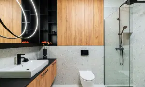 Nowoczesna łazienka inspiracje: drewniane panele, kamień terrazzo, czarna armatura i designerskie oświetlenie tworzą stylową przestrzeń.