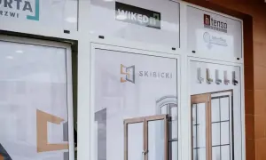 Witryna sklepowa z logo firm okiennych i drzwiowych oraz zdjęciami produktów.