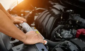 Man checks the engine of a used car, ensuring it's in good condition before purchase.