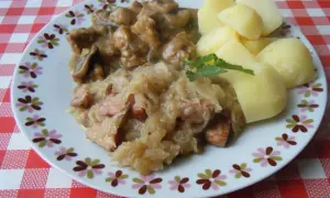 Pyszna kapusta kiszona gotowana z kawałkami mięsa i kiełbasy, podana z ziemniakami.