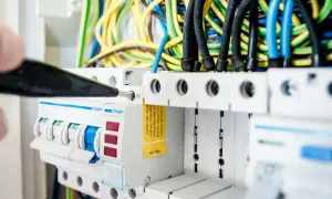En elektriker arbetar med en elcentral, en viktig del för att kontrollera driftskostnad villa.