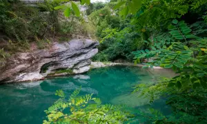 Acque cristalline e rocce imponenti in un angolo di paradiso naturale, un luogo che ricorda la purezza delle terme di Acquasanta.