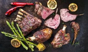 Pieczona dziczyzna z dodatkami: szparagi, cytryna, papryczki chili i kukurydza.