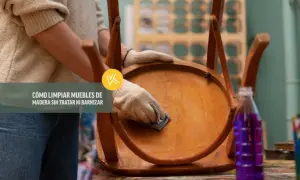 Persona con guantes limpia un mueble de madera, mostrando cómo limpiar madera sin dañar el barniz.