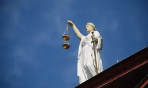 Posąg Temidy z wagą i mieczem na tle błękitnego nieba. Symbol sprawiedliwości, 4cmc.