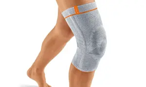 Ein Bein mit einer grauen Kniebandage. Die Bandage könnte bei falscher Anwendung oder zu engem Sitz Schmerzen verursachen.