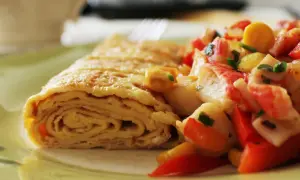 Zrolowany omlet po japońsku z kolorową sałatką z warzyw i surimi.