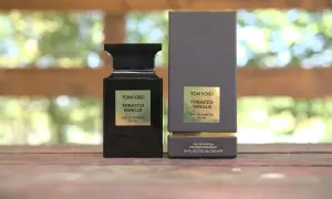 Elegancka butelka i pudełko perfum Tom Ford Tobacco Vanille na drewnianym tle.