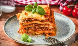 Ein saftiges Stück Lasagne mit Hackfleisch, belegt mit geschmolzenem Käse und garniert mit Basilikum. Ein perfektes Lasagne Rezept mit Hackfleisch für Genießer.