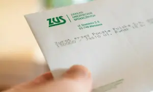 Dłoń trzyma kopertę ZUS. Może to zwrot środków, np. 500 plus dla niepełnosprawnych.