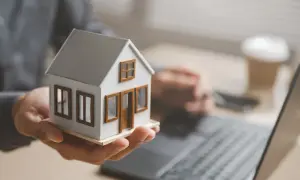 Dłoń trzymająca model domu, symbolizująca planowanie spadkowe. Kto dziedziczy po osobie niezamężnej i bezdzietnej?