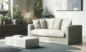 En ljus soffa med lösa dynor i ett modernt vardagsrum. Kanske dags att fixa nedsuttna soffdynor för att ge den nytt liv?