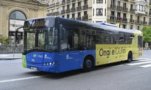 Autobús azul y amarillo de Dbus en Ondarroa, San Sebastián, con el lema "Ongi etorri".