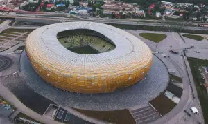 Widok z lotu ptaka na stadion w Gdańsku, z jego charakterystyczną, złotą fasadą. Idealne miejsce na zwiedzanie stadionu gdańsk i poczucie atmosfery wielkich wydarzeń sportowych.