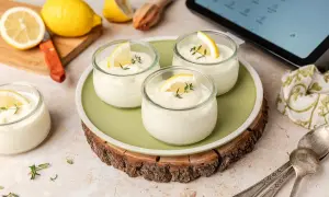 Delicioso mousse de limón Thermomix en vasitos, decorado con rodajas de limón y tomillo. ¡Perfecto para un postre refrescante!