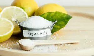 Limoni freschi e un piccolo secchiello con cristalli di acido citrico, che serve per conservare e dare sapore.