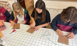 Chicas concentradas en una actividad manual, aprendiendo sobre el IGCSE que es y cómo aplicarlo en proyectos creativos.