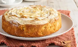 Una deliziosa torta di mele senza burro, decorata con fettine di mela e zucchero a velo, pronta per essere gustata.