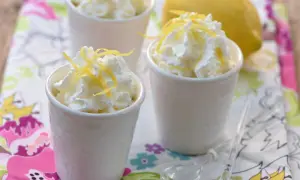 Délicieuse mousse ricotta citron, garnie de zestes frais et servie dans de petits ramequins blancs. Un dessert léger et rafraîchissant.
