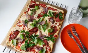 En läcker pizza med bacon och lök, toppad med färska örter och smält ost. Perfekt för en snabb och smakrik måltid.
