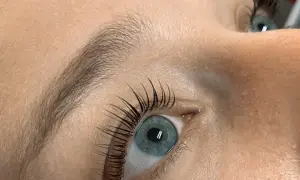 Oko z błękitną tęczówką i pięknie podkręconymi rzęsami po zabiegu Yumi Lashes.