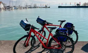 Zwei rote Fahrräder stehen am Ufer des Bodensees in Friedrichshafen, bereit für eine Tour.