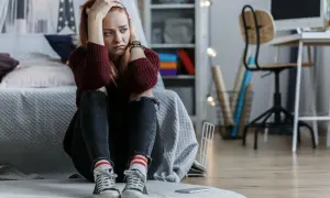 Zmartwiona dziewczyna z rękami na głowie. Szuka sposobu, jak wyleczyć się z obsesji na czyimś punkcie, czując się przytłoczona.