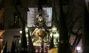 Procesión de Jueves Santo Zaragoza: imagen de la Virgen con el cuerpo de Cristo, rodeada de faroles y capirotes.