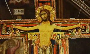 Stary krzyż franciszkański z malowanymi postaciami Jezusa, aniołów i świętych.