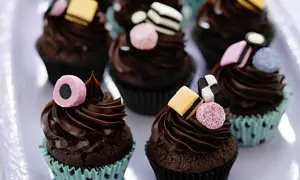 Chokladmuffins med chokladfrosting och godisdekorationer. Ett roligt recept på kakor för barnkalas.