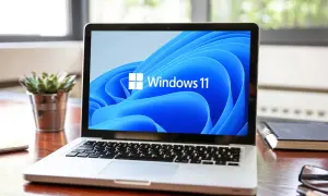 Laptop z logo Windows 11 na ekranie. Sprawdź, czy Twój sprzęt spełnia **windows 11 wymagania**, by cieszyć się nowym systemem.