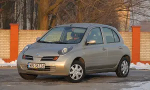 Złoty Nissan Micra K12 z nowymi żarówkami, gotowy na zimowe drogi.