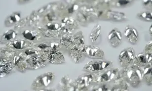 Glitzernde Diamanten in verschiedenen Schliffen, darunter Marquise und Tropfen, liegen verstreut. Ihr perfekter diamanten schliff fängt das Licht ein.