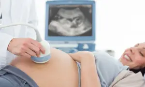 Radość przyszłej mamy podczas badania USG. Specjalista wykonuje badanie w ramach perinatologii, monitorując rozwój dziecka.
