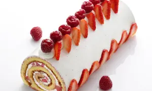 Un délicieux roulé fraise mascarpone, orné de fruits rouges frais et de fines tranches de fraises, invite à la gourmandise.