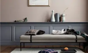 Ein Tagesbett mit Kissen und Decken vor einer Wand in einem sanften Rosaton. Welche Farbe wirkt beruhigend? Dieses Rosé schafft eine friedliche Atmosphäre.