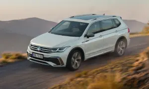 Biały Volkswagen Tiguan Allspace przemierza górską drogę.