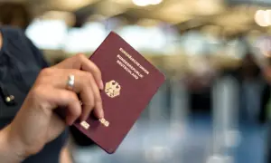 Ein deutscher Reisepass, der nass geworden ist, wird von einer Hand gehalten. Die Seiten sind leicht gewellt.