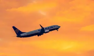 Samolot Ryanair wznosi się na tle pomarańczowego nieba. Idealny na krótkie wycieczki 4 dniowe samolotem.